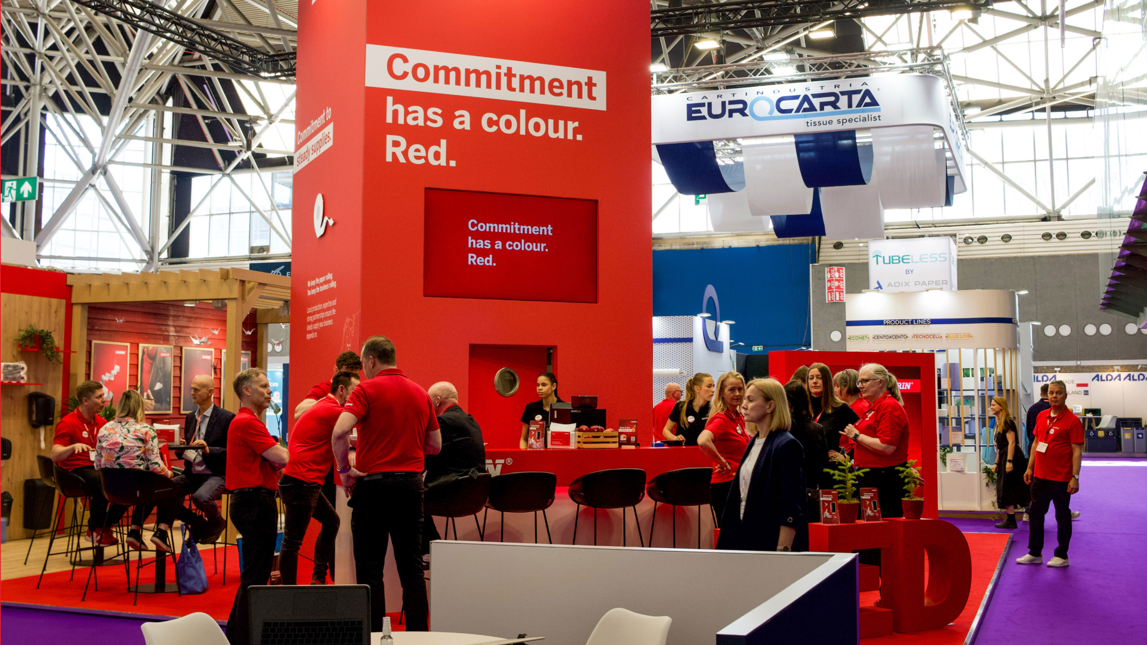 Katrin's red trade fair stand at Interclean Amsterdam 2026 with meeting spaces, visitors and the message “Commitment has a colour. Red.