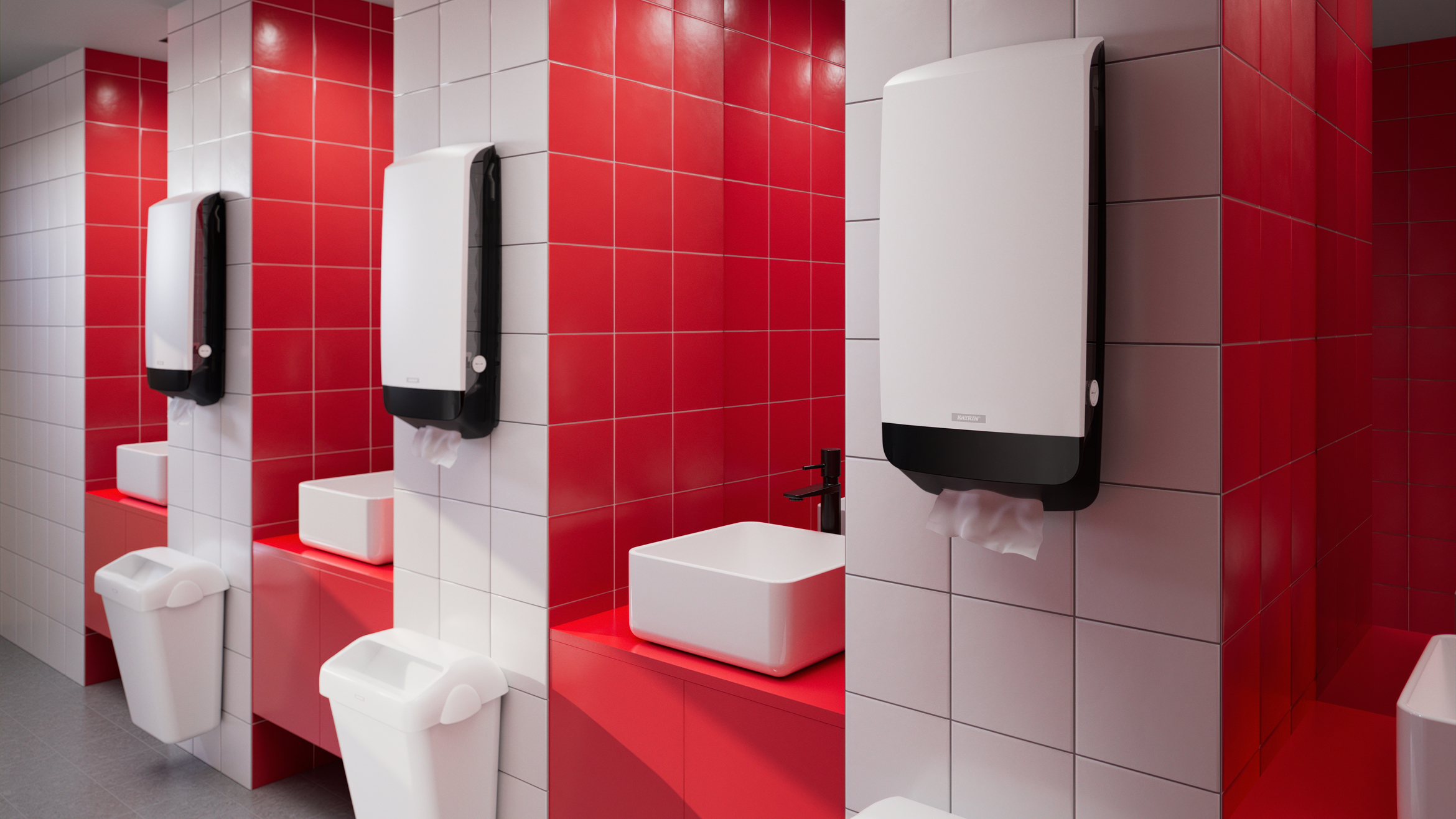Toalettutrymme med röda och vita kakelväggar och väggmonterade Katrin XL Dispensers ovanför handfat.