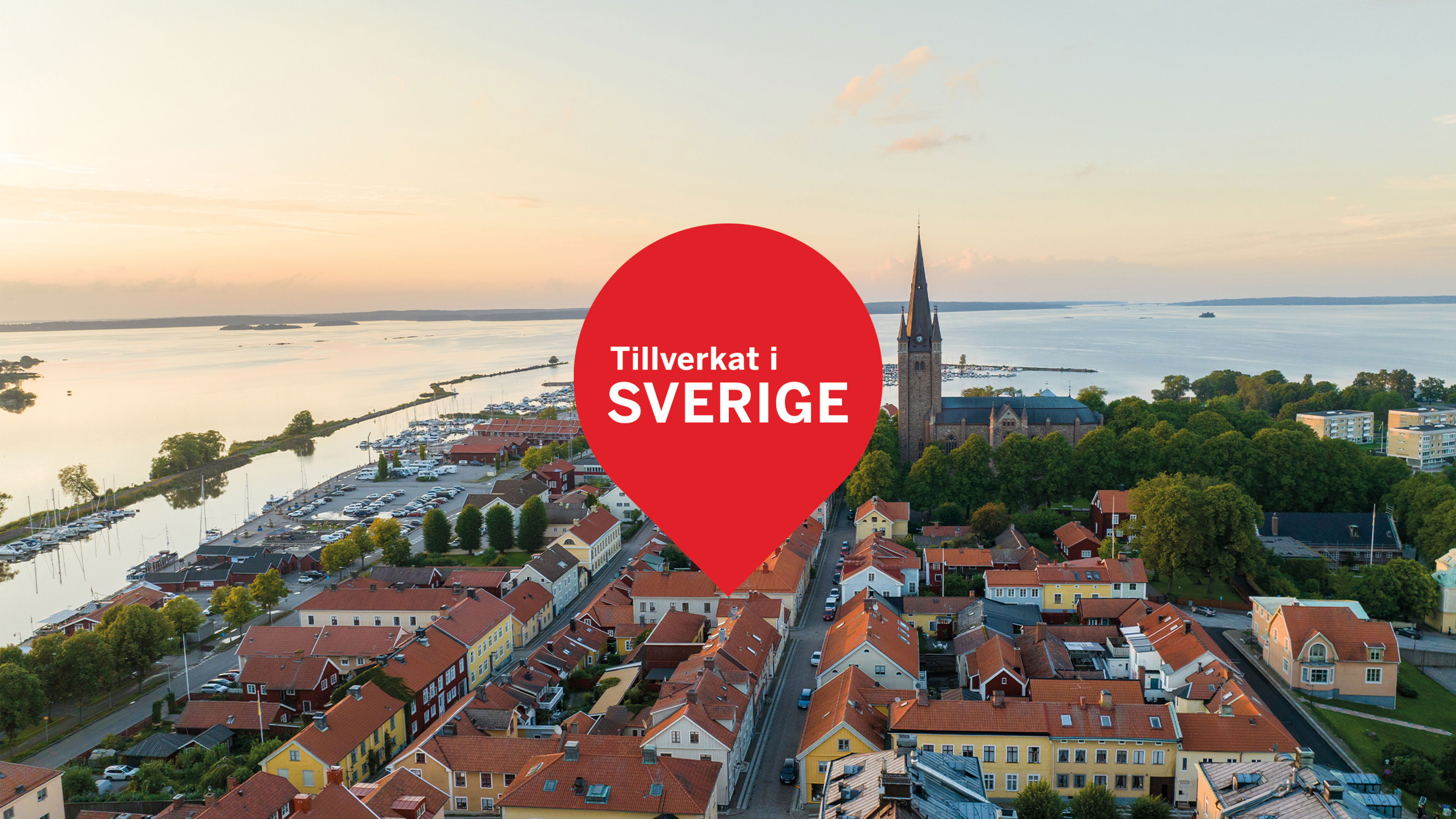 Flygbild över Mariestad med en röd kartmarkör och texten "Tillverkat i Sverige".