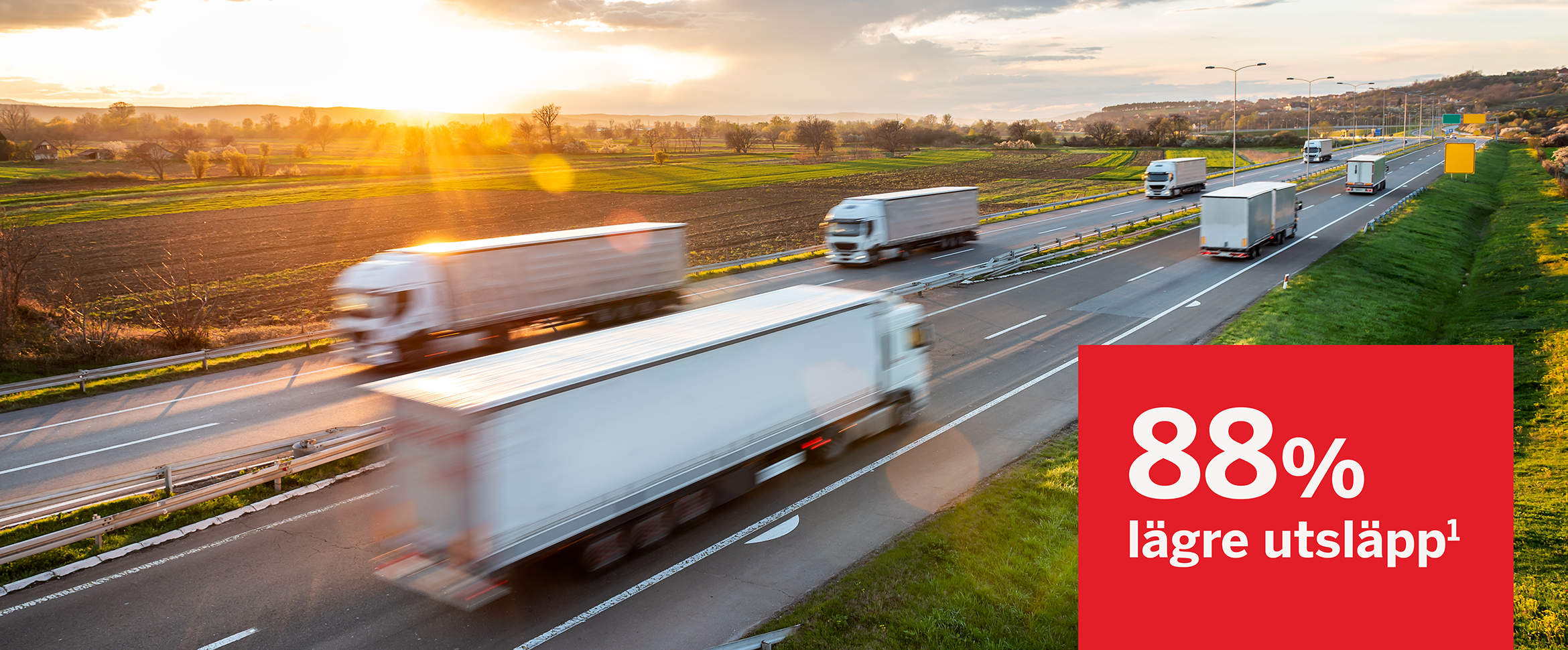 Flera lastbilar k&ouml;r l&auml;ngs en motorv&auml;g i solnedg&aring;ng, med en skylt som visar "88 % l&auml;gre utsl&auml;pp&sup1;", vilket syftar p&aring; minskad klimatp&aring;verkan fr&aring;n kortare transporter.