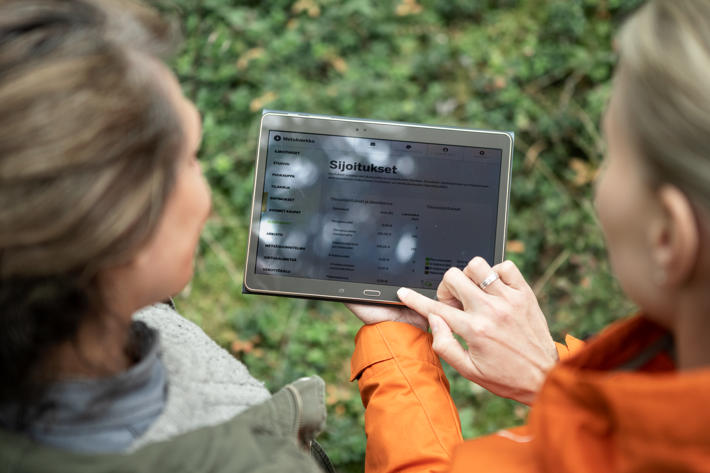 A forest specialist and forest owner looking at Metsäverkko on a tablet.