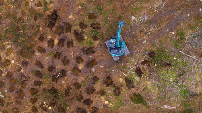 An excavator performing inverting, photo shot from the air.