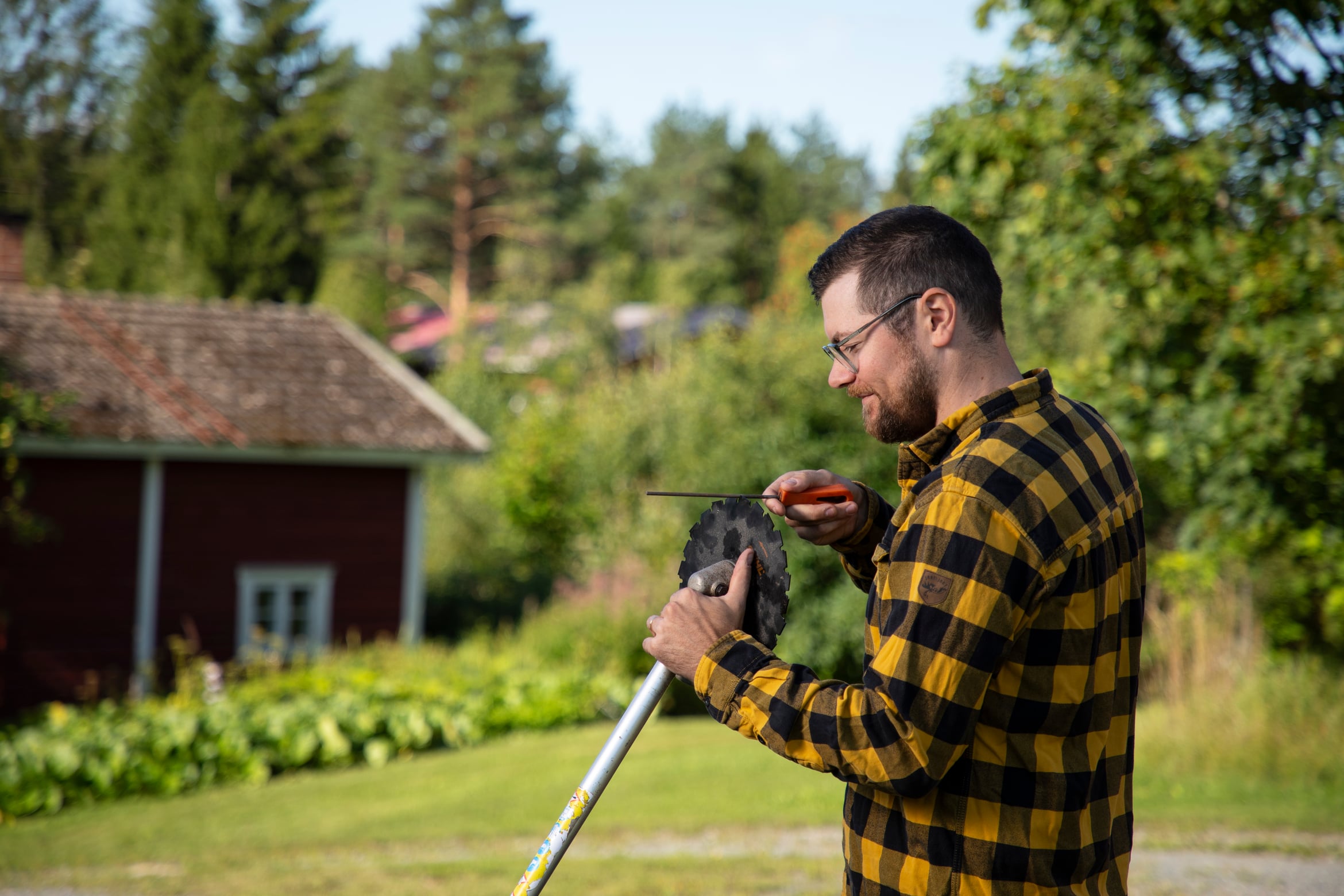 Kalle Linkki teroittaa raivaussahaa.
