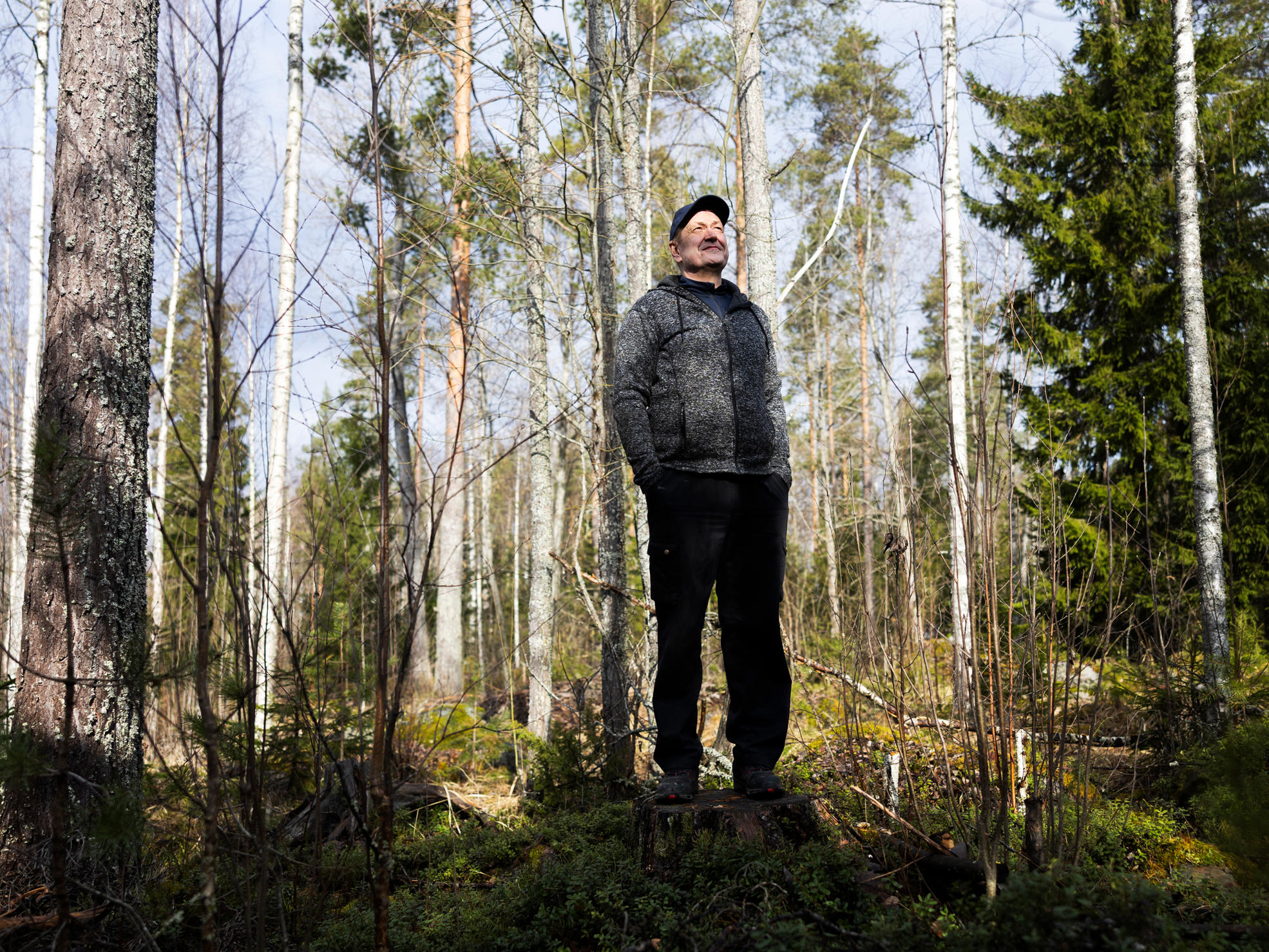 Skogsägaren står i sin skog.