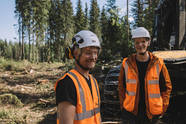 Drivningsentreprenör och Metsä Groups operativa förman står i skogen framför skördare.