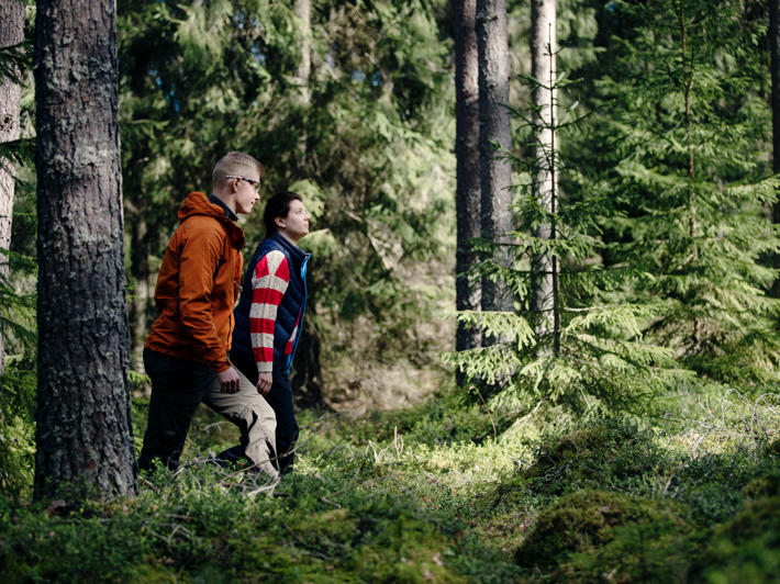 Skogsexpert och skogsägare går i skogen.
