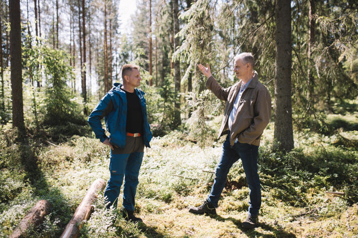 Metsäasiantuntija ja metsätalousyrittäjä keskustelevat metsässä.