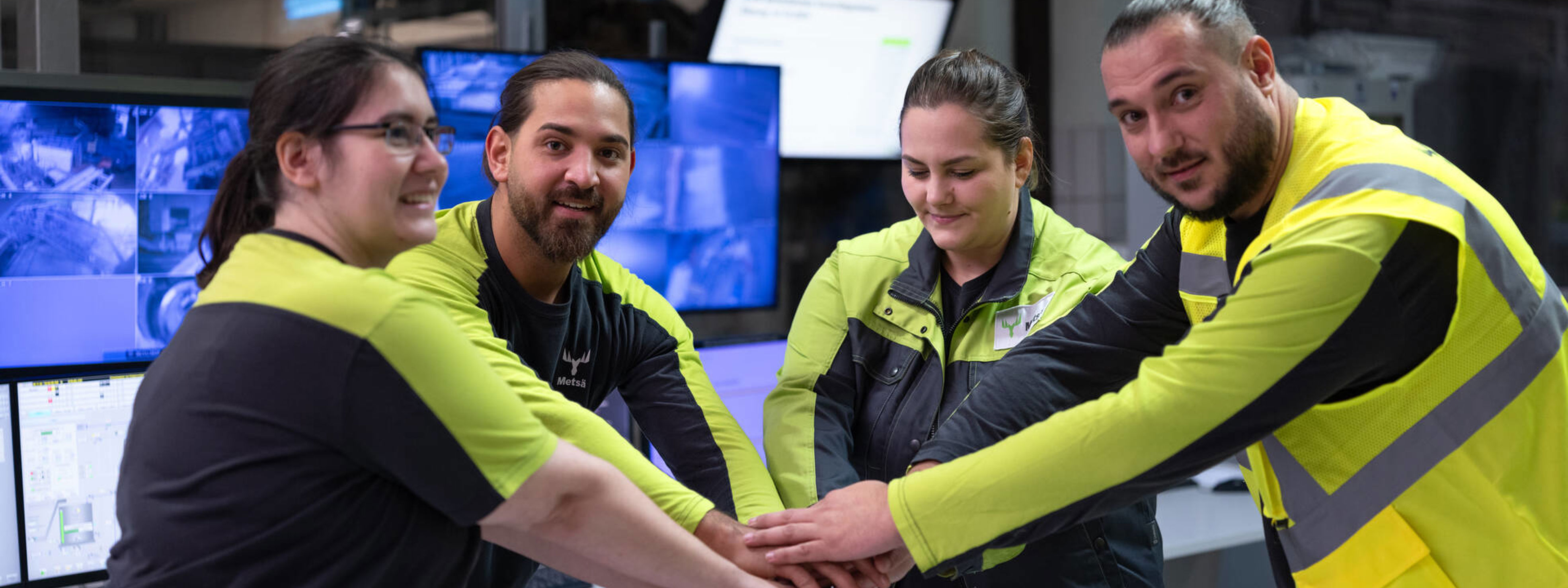 Two employees are having a chat in the maintenance workshop of the Renko sawmill, they are standing next to a shelf of circular saw blades